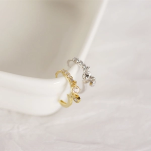 Macro shot of silver and gold teardrop hoop earrings with pavé diamond crystals