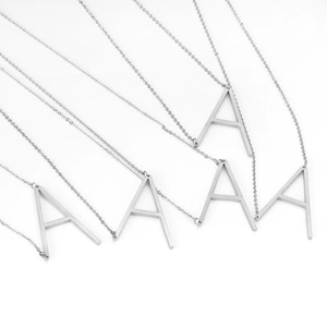 Detail of silver stainless steel necklaces with polished uppercase letter A pendants
