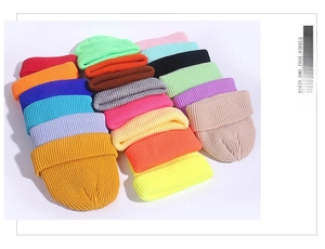 Vertical stack of colorful ribbed knit beanies showing various vibrant colors