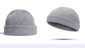 Detail view of the light grey knitted brimless skull cap showing textured stitch quality