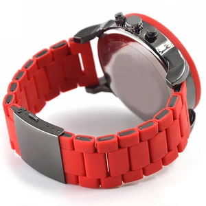 Detail of red silicone watch strap and gunmetal folding clasp on a sport quartz watch