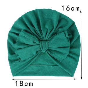 Cappellino neonato in maglia verde con grande fiocco, dimensioni 18cm per 16cm