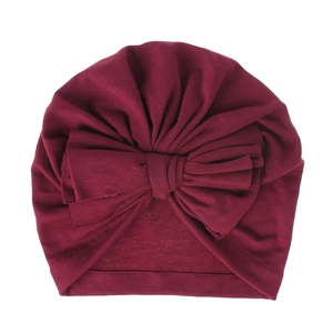 Dettaglio di un morbido cappello a turbante per neonati in cotone con grande fiocco