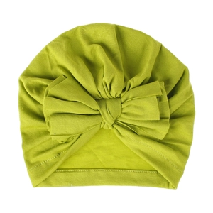 Dettaglio del turbante per neonati in cotone lavorato verde erba con grande fiocco