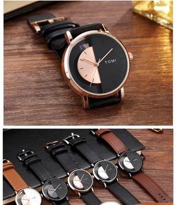 Detailed close-up of a TOMI hollow dial quartz watch with leather strap on a wooden desk