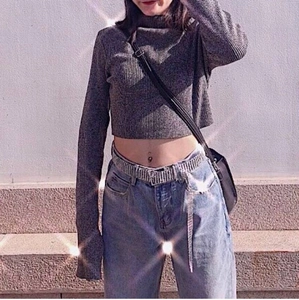 Close-up of luxury ten-row rhinestone waist belt styled on grey ribbed crop top