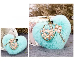 Close-up of heart-shaped plush keychain with cat eye stones and metallic clover charms