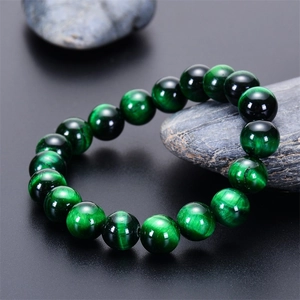 Macro detail showing natural green tiger eye stone beads with Chatoyancy effect on bracelet