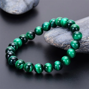 Macro detail of natural green tiger eye beaded bracelet with cat eye effect on raw stone