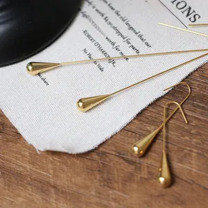 Macro shot of gold-plated teardrop earrings showing polished finish and sleek texture