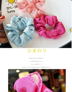 Close-up of pleated satin hair scrunchies showing glossy texture and vibrant colors