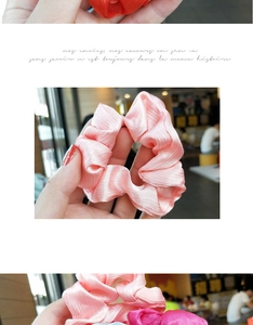 Detail of ruched satin hair scrunchies with wavy texture and shimmering metallic finish