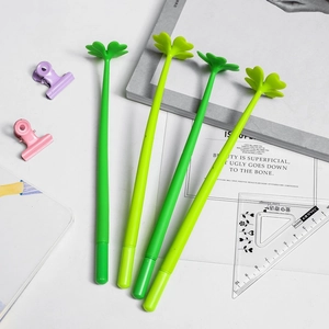 Set of 4 creative green clover shaped gel pens on a white desk with stationery