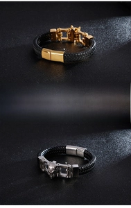 Detail of men's leather braided bracelets with gold clasp and silver wolf head carving