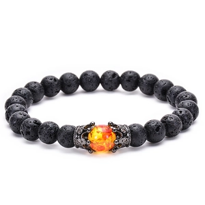 Close-up of black volcanic lava beads and orange amber resin bead with crown spacers