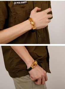 Close-up of golden lion head emblem on black braided leather motorcycle bracelet for men
