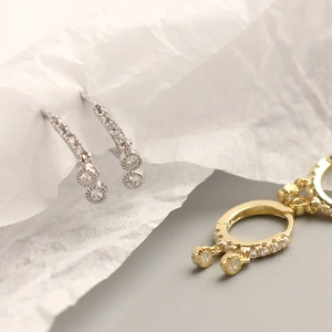 Close-up of S925 sterling silver and gold hoop earrings with sparkling cubic zirconia drops