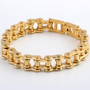 Macro view of gold stainless steel motorcycle chain bracelet on a white background