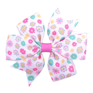 Close-up of floral ribbon hair clip with pink, blue and yellow daisy patterns