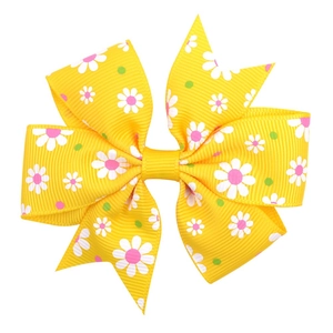 Close-up of yellow grosgrain ribbon bow hair clip with daisy and polka dot prints