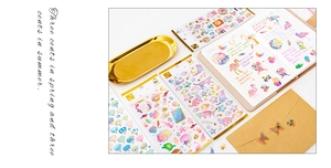 Detailed view of gold-stamped crystal epoxy stickers on a notebook with stars and cats