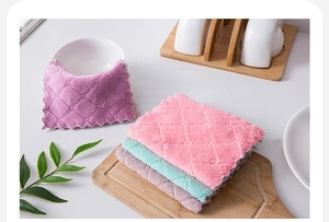 Macro detail of diamond-quilted microfiber dishcloths stacked on a wooden board