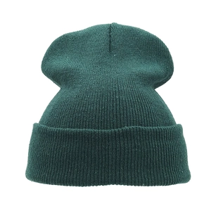 Close-up of the dark green knitted texture and folded cuff of this winter wool beanie