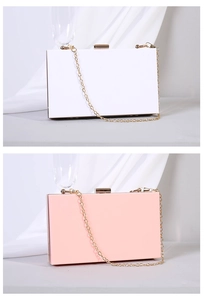 Detail of white and pink acrylic box clutch bags with elegant gold metal chains