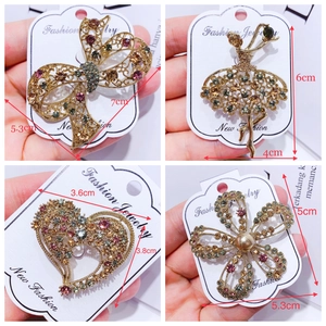 Detailed views of gold-plated animal brooches with colorful rhinestones on cards