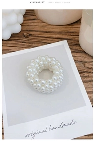 Detailed macro view of minimalist handmade multilayer pearl elastic hair tie and bracelet
