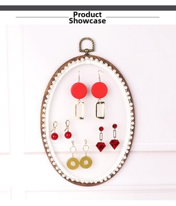 Close-up of assorted vintage earrings on a lace-bordered wooden mesh display rack