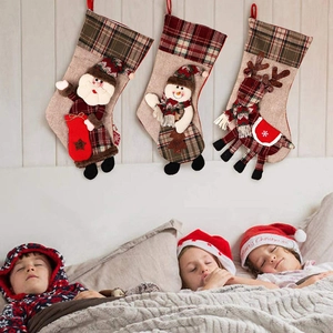 Trois chaussettes de Noël en lin avec Père Noël et bonhomme de neige suspendues au lit