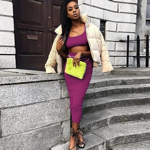 Outdoor street style view of woman wearing purple crop top and matching midi skirt set