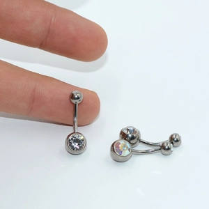 Detailed close-up of G23 titanium belly rings with sparkling double crystals in hand