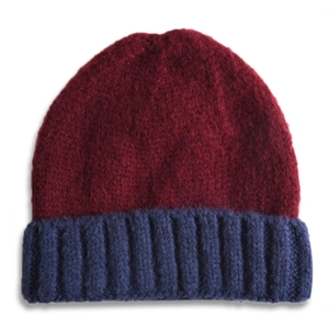 Détails de texture du bonnet en laine tricoté bicolore bordeaux et bleu marine pour enfant