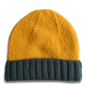Détail du bonnet tricoté bicolore pour bébé avec haut jaune et bord côtelé vert foncé