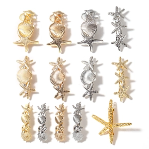 Gold and silver ocean style hair clips with starfish, shells and pearls on white background