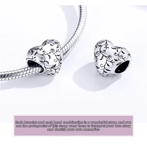 Detailed macro view of S925 sterling silver heart bead with vintage vine engraving