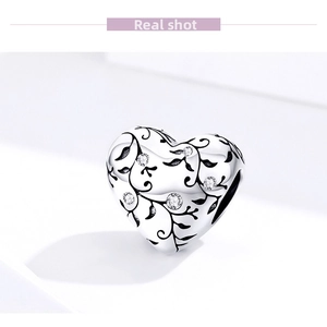 Macro shot of S925 sterling silver heart charm with vine engravings and zircon stones