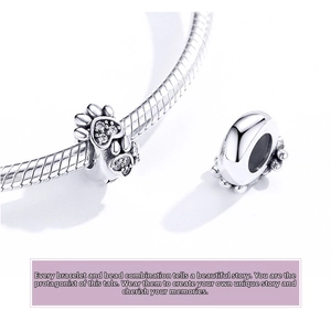 Macro shot of silver heart-shaped paw print charm with clear zircon on snake chain