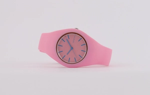 Close-up of pink silicone strap watch with a pink dial and contrasting blue hands