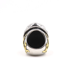 Macro detail of retro stainless steel skull ring with dual guns and gold relief accents