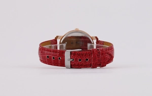 Detail of red crocodile texture leather strap and rose gold watch case with buckle