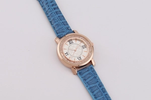 Detail of light blue faux leather strap and crystal-studded rose gold case with Roman numerals