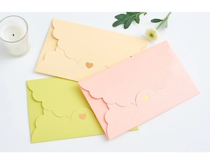 Detail of scalloped edge envelopes with heart shaped laser cut closure in pastel colors