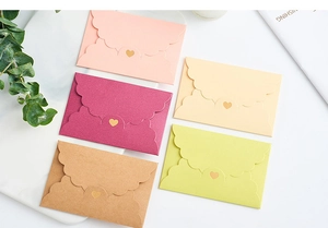 Detailed view of mini envelopes with wavy flaps and gold heart seals in five pastel colors