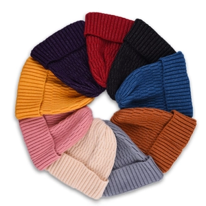 Assorted soft knit beanies in ten vibrant colors arranged in a circle on white background