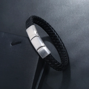 Detail of black braided leather bracelet with brushed silver magnetic metal clasp