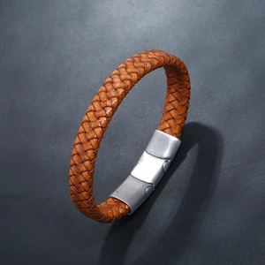 Close-up of woven caramel brown leather bracelet with brushed metal magnetic clasp