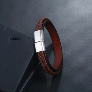Close-up of brown braided leather bracelet with silver magnetic clasp on box